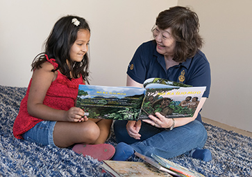 Rotary member reading to a child.